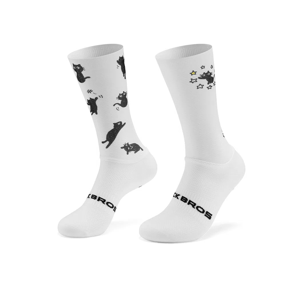 A pair of white crew socks with black cat illustrations and the brand name 'ROCKBROS' printed on the toes, shown against a plain white background. #Color_cat