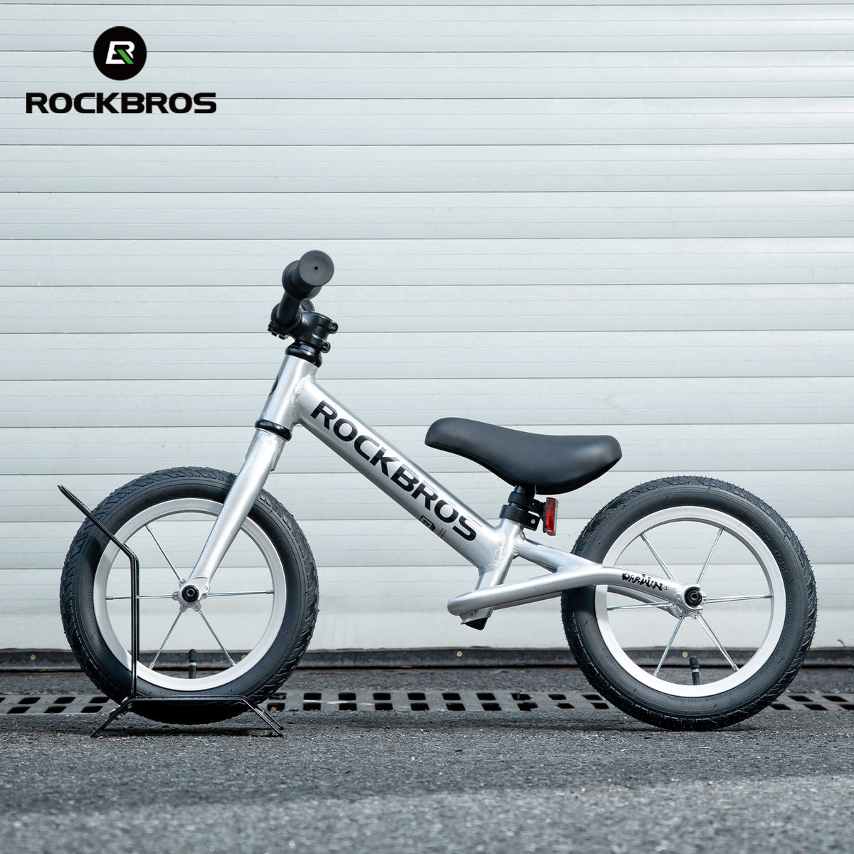 White balance bike with black seat on a gray background, featuring the RockBros brand.
