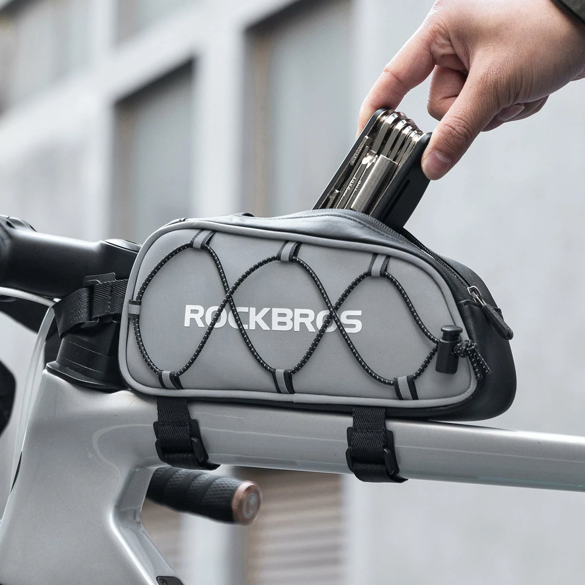 Gray bike frame bag with 'RockBros' branding attached to a bicycle handlebar. #color_silver