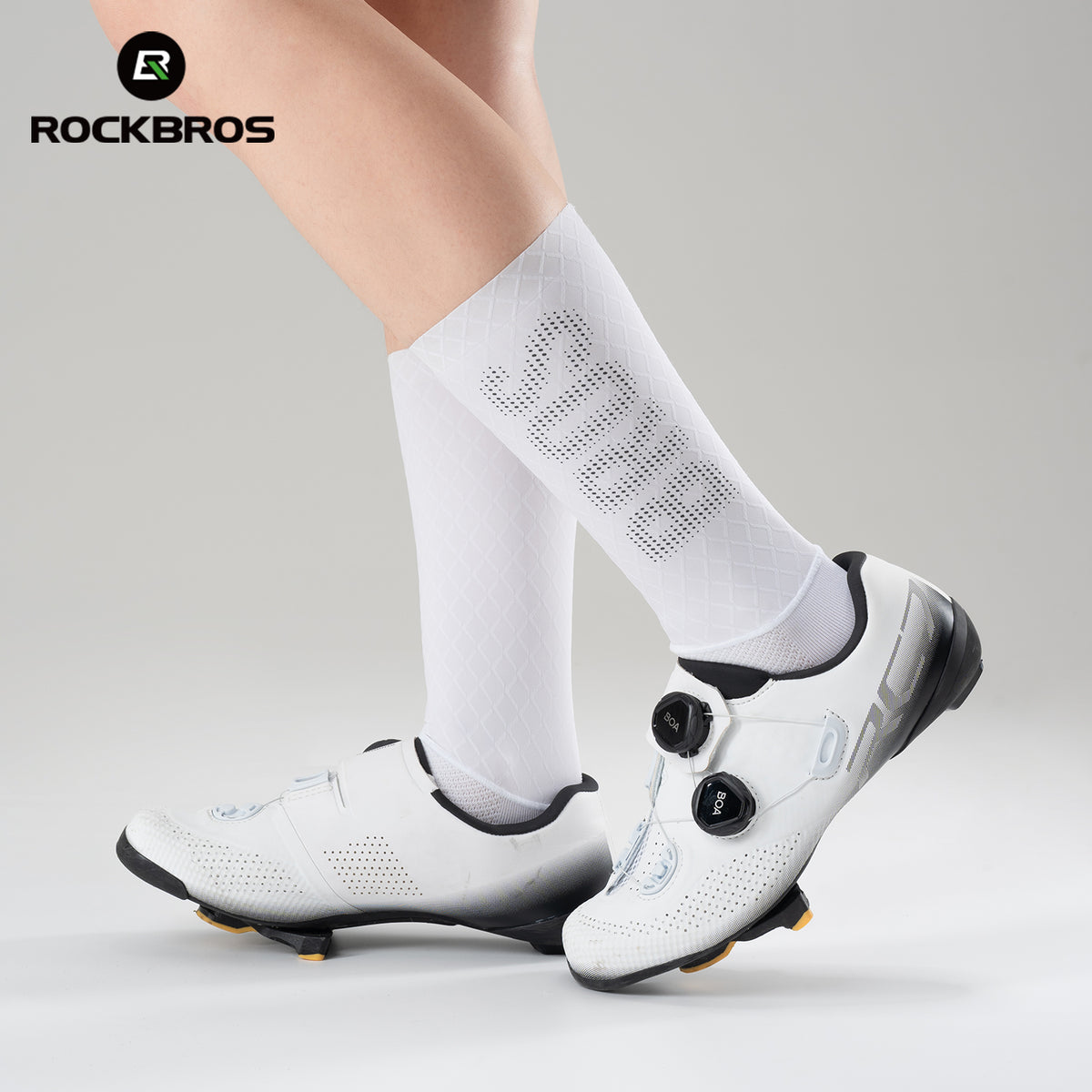White cycling shoes with black accents worn with white socks on a light gray background, featuring the RockBros brand.#color_White Mesh - Silver Label