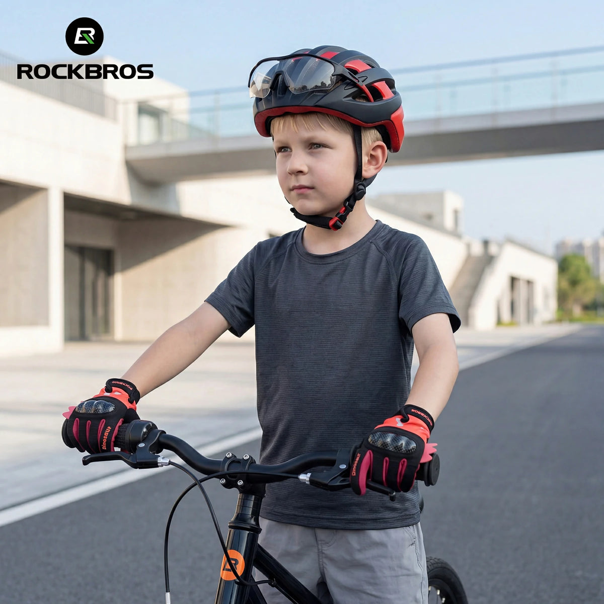 Child wearing a red and black helmet and gloves, standing next to a bicycle on a road. #color_red