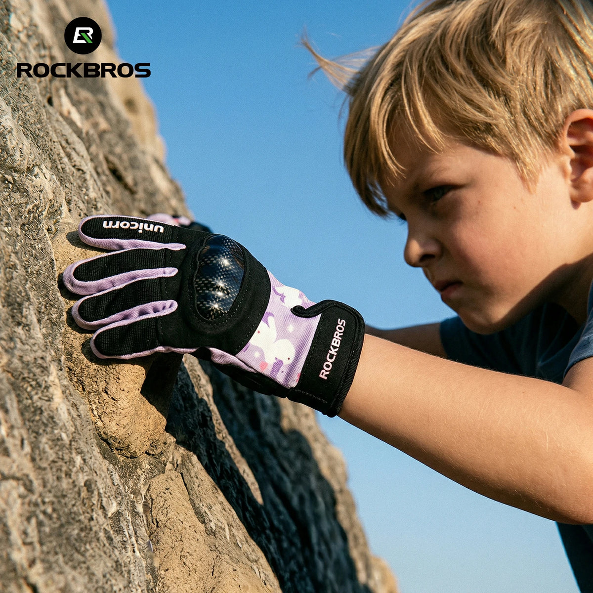 Child climbing a rock face wearing a glove with 'RockBros' branding. #color_purple