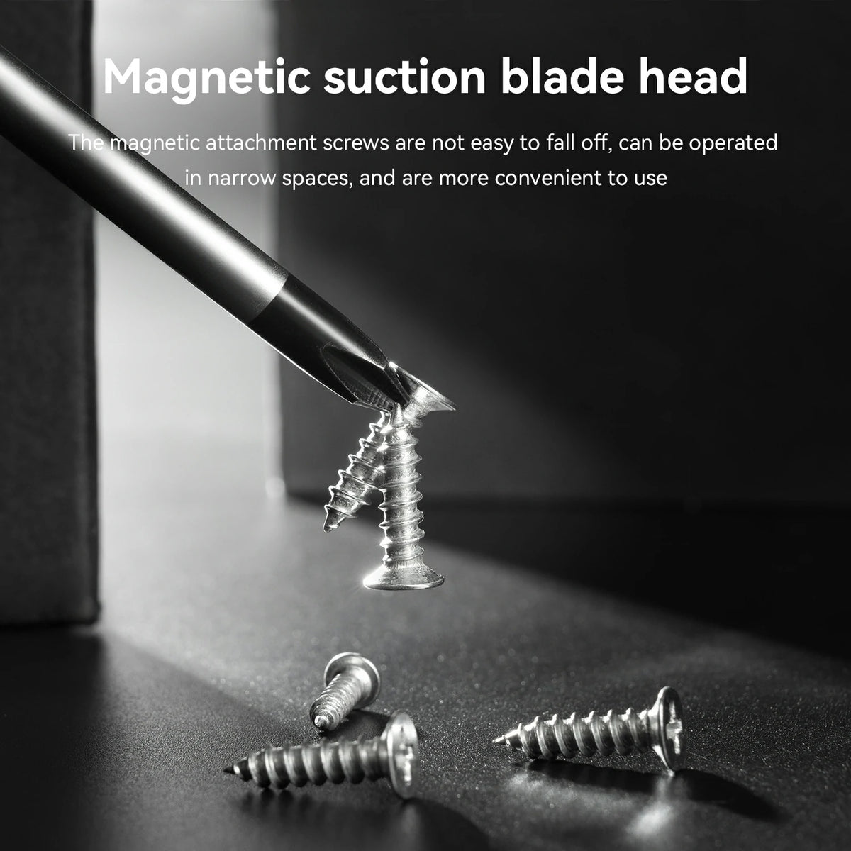 A close-up product demonstration showing a magnetic suction blade head attached to a screwdriver bit, holding a metal screw against a dark surface. White text at the top reads 'Magnetic suction blade head' with additional descriptive copy below, and several loose screws are scattered on the surface.