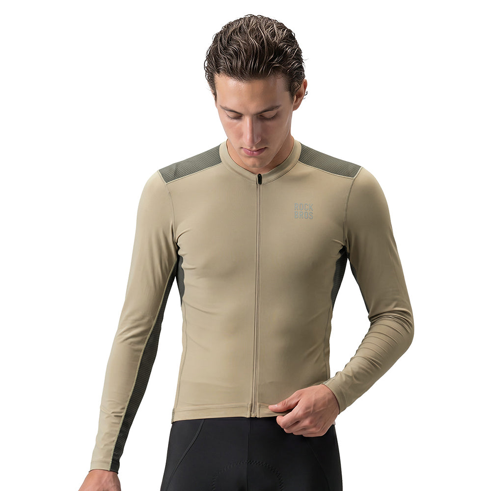 A man wearing a beige long-sleeve cycling jersey with dark gray shoulder and side panels, paired with black cycling shorts, against a plain white background. #Color_khaki