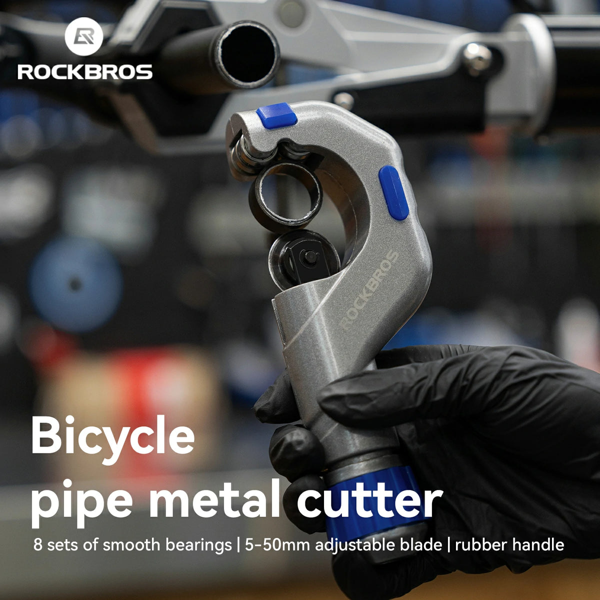 A Rockbros bicycle pipe metal cutter held by a black-gloved hand, with the brand name and product text overlaid on a blurred workshop background.