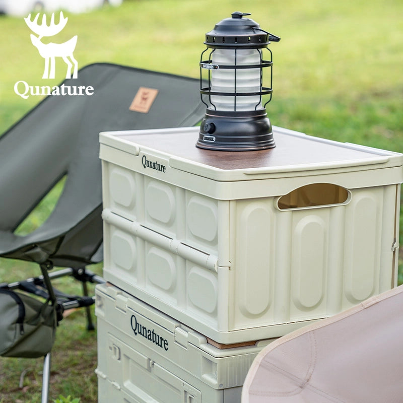Stack of Qunature coolers with a lantern on top, outdoors.