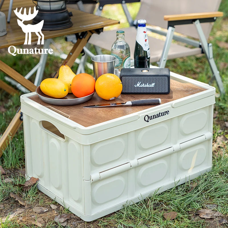 Qunature outdoor storage box with a wooden top, fruits, and a speaker on a grassy background.