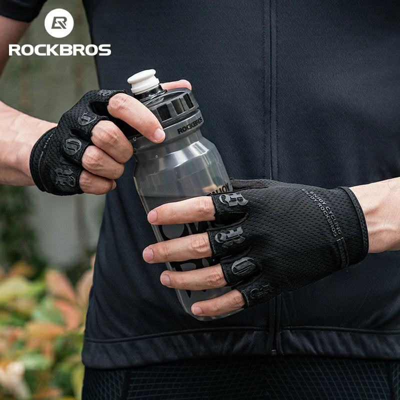 Person holding a water bottle with gloves on, wearing a black jacket with 'RockBros' branding. #color_black