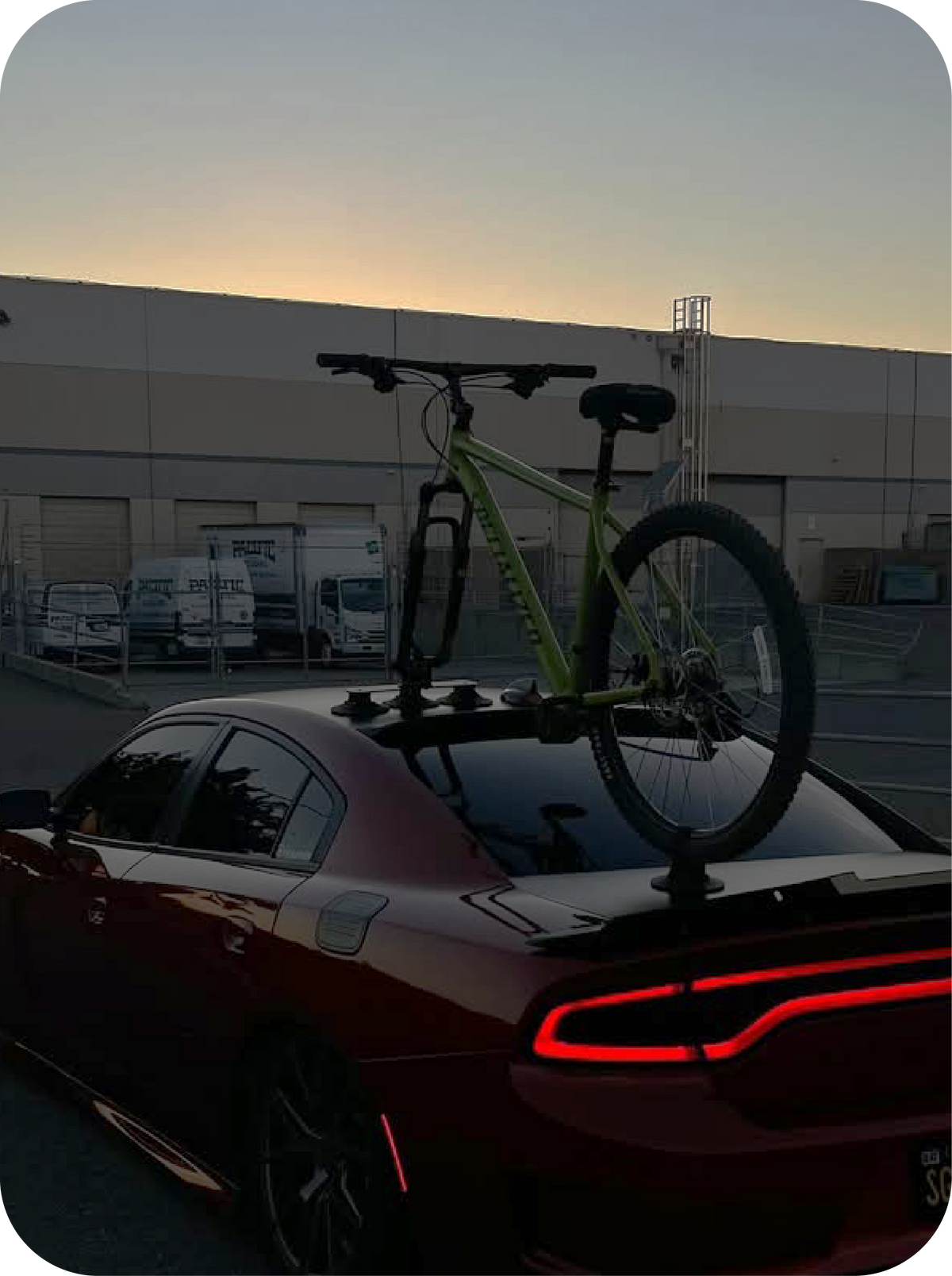 Bicycle on a ROCKBROS car roof rack with a building and sunset in the background