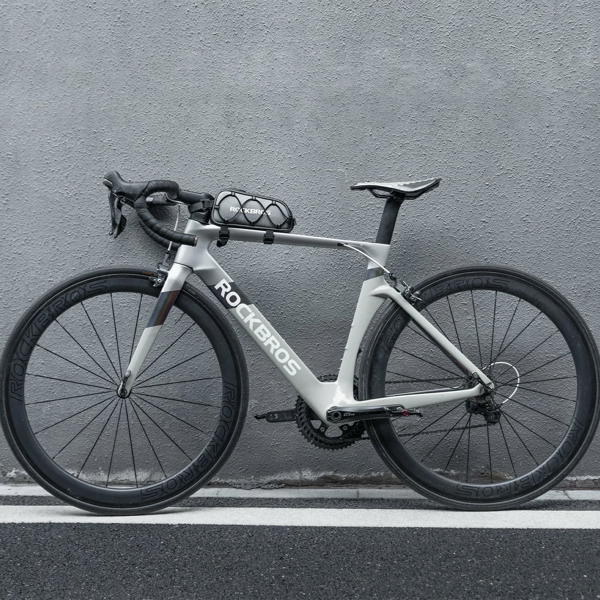 White bicycle with 'ROCKBROS' branding against a gray wall  #color_silver