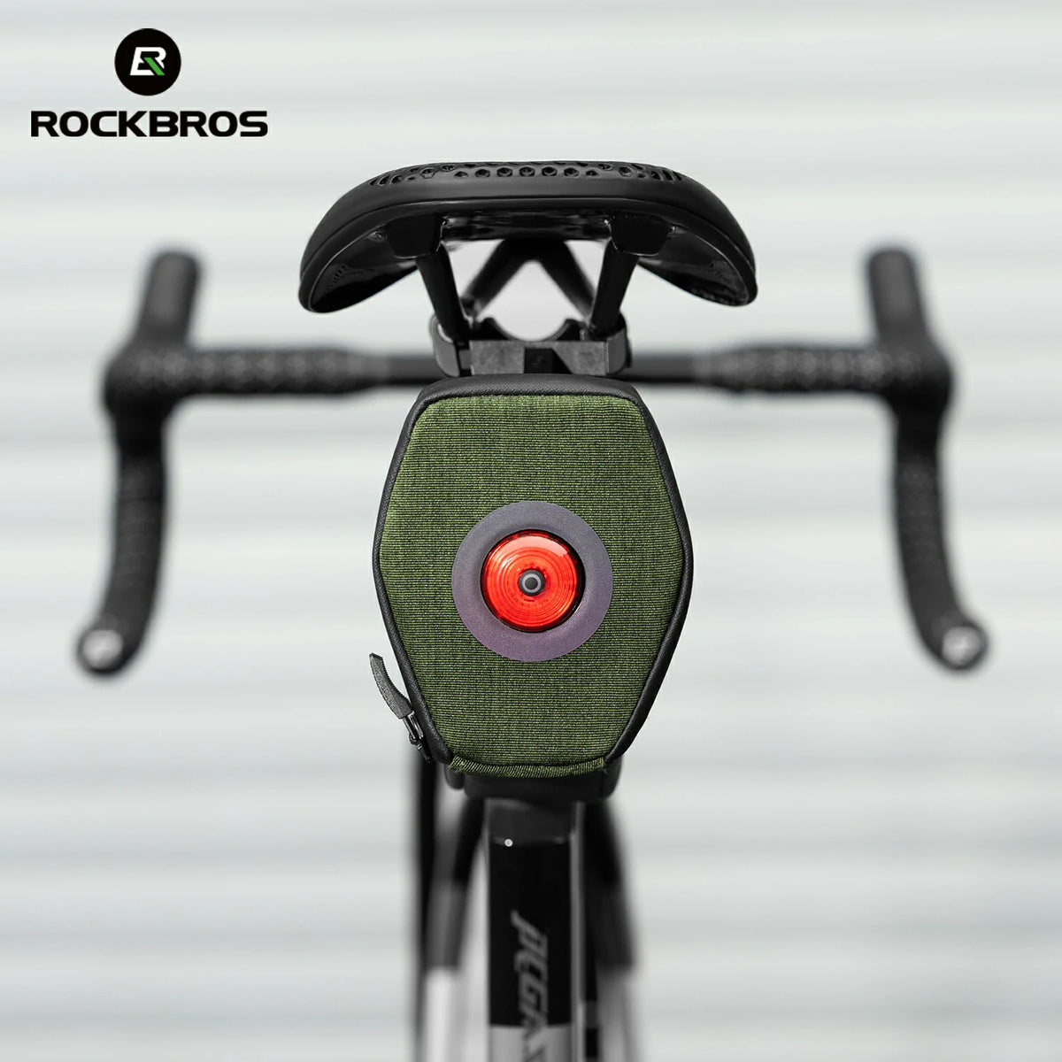 Close-up of a bicycle with a green light and red center, branded with RockBros. 