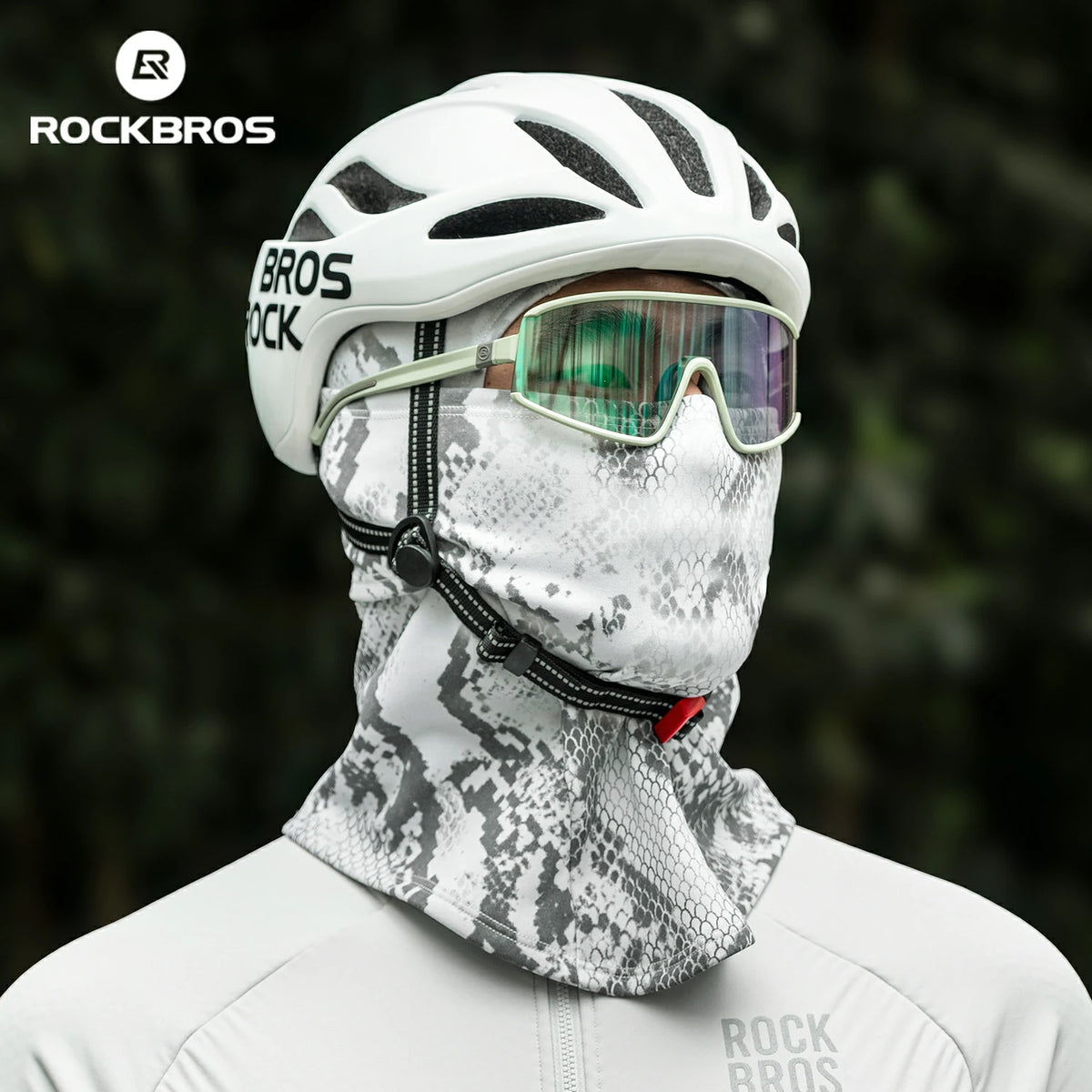Person wearing a white helmet, goggles, and camouflage neck gaiter with RockBros branding. #color_Serpentine gray