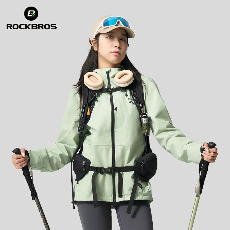 Person wearing a light green jacket with hiking gear, holding poles, on a gray background with RockBros logo. #Color_green