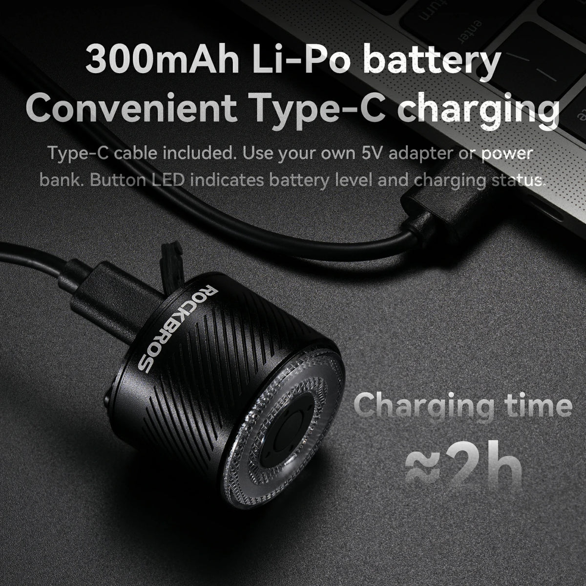 Black electronic device with charging cable on a dark background, featuring text about battery and charging details.