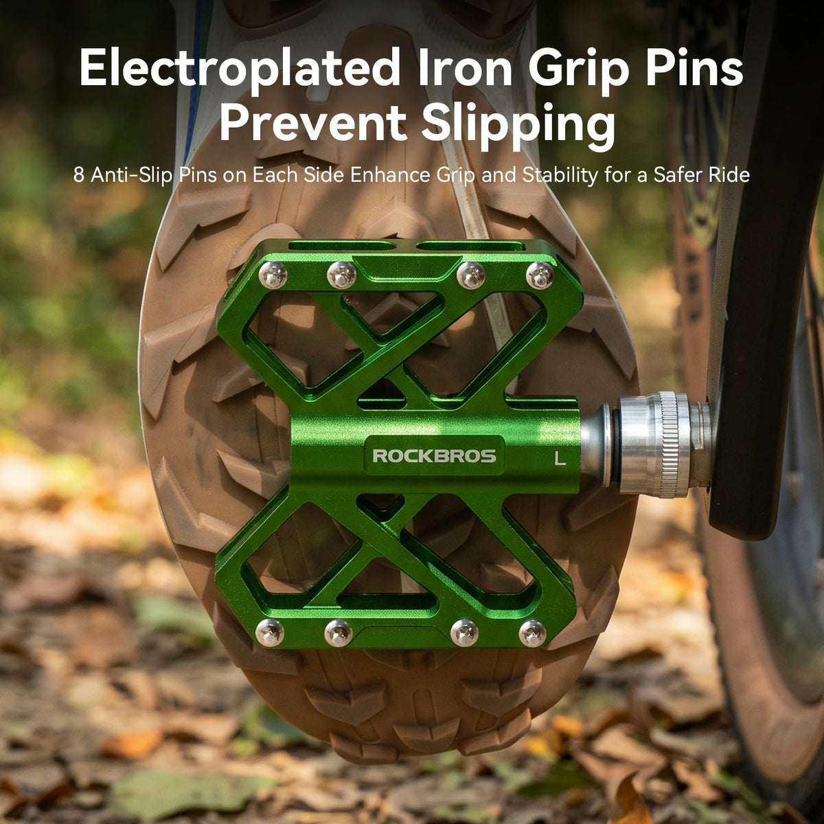 A close-up of a green Rockbros bicycle pedal with silver anti-slip grip pins attached, mounted on a tire on an outdoor trail with text overlay at the top.